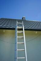 Ladder on the roof. Ladder leading to the roof. House cleaning. photo