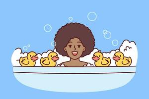 Little African American girl bathes in bubble bath with rubber ducks and looks at screen smiling. Cheerful child, surrounded by soap bubbles, bathes and enjoys performing useful hygiene procedures. vector