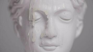 drops of wax falling on the face of an antique statue video