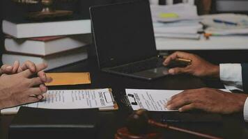 Business and lawyers discussing contract papers with brass scale on desk in office. Law, legal services, advice, justice and law concept picture with film grain effect video