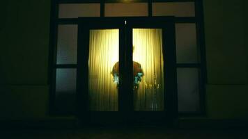 ein asiatisch Mann Spaziergänge und öffnet das Tür von ein Haus ausgestattet mit Gelb Beleuchtung video