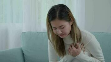 hand hold chest with heart attack symptoms, asian woman have chest pain caused by heart disease, leak, dilatation, enlarged coronary heart, press on the chest with a painful expression video