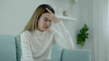 Headache, female having migraine pain, bad health, Asian woman feeling stress and headache, Office syndrome, sad tired touching forehead having migraine or depression, irritated girl, sadness grief video