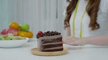 Beauty slim female body confuse chocolate cake. Woman in restaurant achieves weight loss goal for healthy life, crazy about thinness, thin waist, nutritionist. Diet, body shape. video