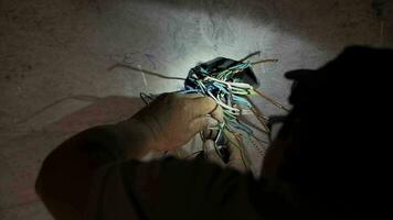 hombre electricista conecta alambres eléctrico ingeniero trabajando en sitio. video