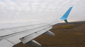 View from the airplane window on the city, takeoff and climb. Porthole, airplane wing video