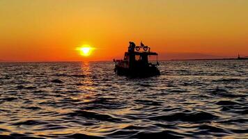 rekreations båt och människor rör på sig i hav på solnedgång antal fot. video
