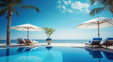 Luxurious swimming pool and loungers umbrellas near beach and sea with palm trees. photo