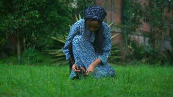 an Asian woman walking on the grass in a green park while wearing a blue dress video