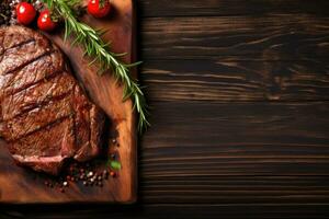 Grilled meat barbecue steak on wooden cutting board with rosemary and copy space. Top view. photo