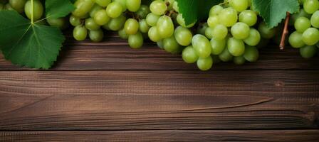 Green juicy grapes on wooden background. photo