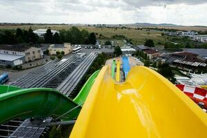 Yellow and green water slides on the background of the city in summer. photo