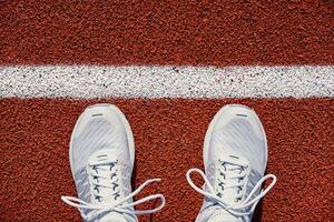 White running sneakers at stadium track photo