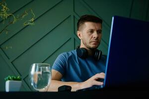 Man working remotely at home office with laptop photo