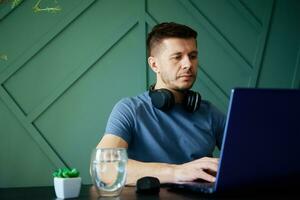 Man working remotely at home office with laptop photo