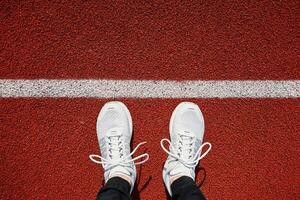 White running sneakers at stadium track photo