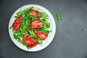 rojo tomate ensalada Rúcula sano comida comida bocadillo en el mesa Copiar espacio comida antecedentes rústico parte superior ver foto