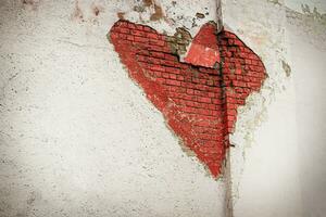 rojo corazón pintada en un blanco ladrillo pared en blanco yeso hecho en el apertura en el hormigón foto