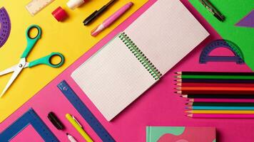 Stopmotion animation of composition of multi-colored stationery items laid out on the table. office, school FLAT LAY pink, yellow, green background. Copy space notebook. 4k footage, video, motion video