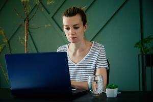 Woman working remotely at home office with laptop photo