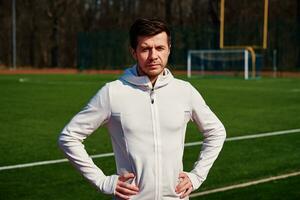 Portrait of man preparing for fitness at stadium track photo