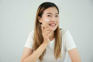 Beautiful Asian woman smile use cream for good skin. face of a healthy woman apply cream and makeup. Advertisement for skin cream, anti-wrinkle, baby face, whitening, moisturizer, tighten pores serum photo