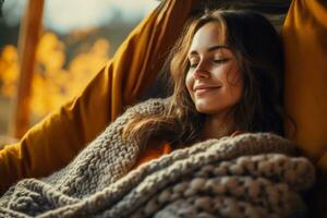 Person snuggling up with a blanket on a hammock in a cozy sweater photo