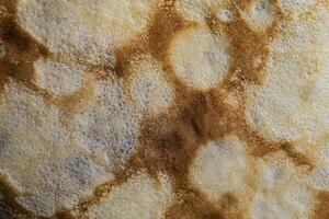 Pancake surface texture and pattern. Close-up of thin hot pancakes in a plate. Traditional rustic food. Graphic resource. photo