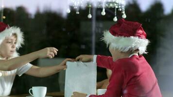 two children in santa hats are sitting at a table video