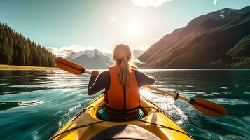 Young woman kayaking on mountain lake. Adventure and sport concept photo