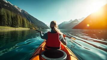 Young woman kayaking on mountain lake. Adventure and sport concept photo