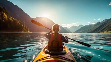 Young woman kayaking on mountain lake. Adventure and sport concept photo