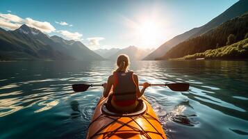 Young woman kayaking on mountain lake. Adventure and sport concept photo