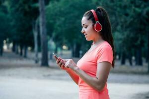 Caucasian woman listening to music while exercising in a park photo