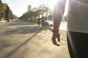 un de cerca Disparo de un rojo reloj en un masculino mano caminando en el calle en un soleado día foto