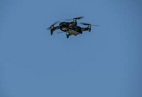 drone moving the blades flying through the blue sky photo