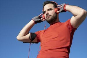 joven hombre preparando a correr con un par de auriculares foto