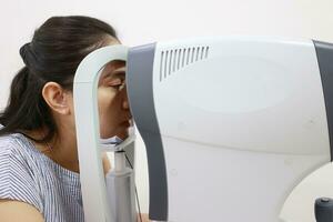 Eye exam concept, woman eye test in clinic, beautiful girl wearing eyeglass on blur optical shop background photo