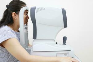 Eye exam concept, woman eye test in clinic, beautiful girl wearing eyeglass on blur optical shop background photo