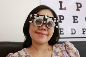 Woman wearing trial frame of eye test. eye exam concept, woman eye test in clinic, women eye exam in clinic photo