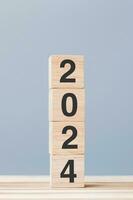wooden cube block with 2024 text on table background. Resolution, plan, review, goal, start and New Year holiday concepts photo