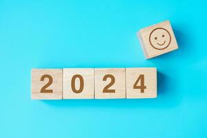 Smile face block with 2024 text on blue background. Satisfaction, feedback, Review and New Year concepts photo