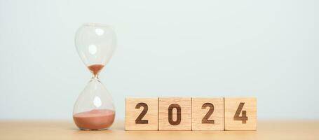 2024 text with hourglass on table. Resolution, time, plan, goal, motivation, reboot, countdown  and New Year holiday concepts photo