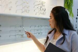 Ophthalmologist holding notebook inside eyeglass clinic, eye doctor in optical store photo