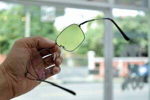 Hand holding eyeglass, eyeglasses in hand, hand holding glasses in optical store photo