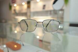 Closeup of eyeglass in optical store, glasses on the glass in clinic photo