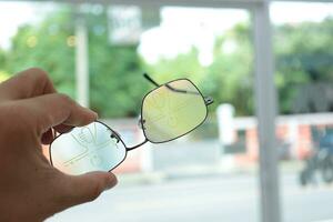 Hand holding eyeglass, eyeglasses in hand, hand holding glasses in optical store photo