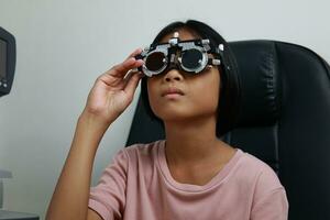 Child eye test in optical store, kid eye check in clinic photo