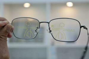 Hand holding eyeglass, eyeglasses in hand, hand holding glasses in optical store photo