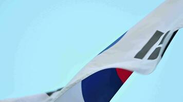 ein Nahansicht von das Süd Koreanisch Flagge, das Taegukgi, flattern im das Wind gegen ein klar Sommer- Himmel. video